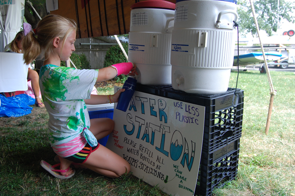 Simple, traditional water cooler refill stations keep the water cold and racers hydrated! Child refilling with water cooler
