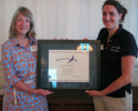 Annie Brett, Sailors for the Sea program director hands Diana Brown of Nantucket Community Sailing their Gold Level Clean Regatta Certification. Clean Regatta Certification